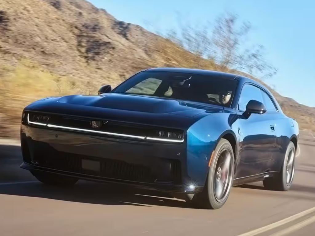 A black Dodge Charger Daytona drives on a desert road.