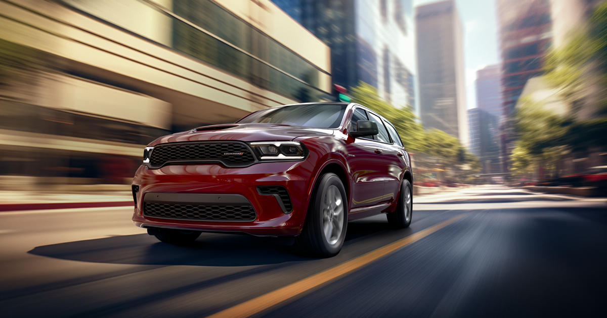 A Dodge Durango racing towards the viewer, driving fast through the city